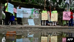 FILE - People hold placards during an awareness campaign against mosquito-borne diseases, in Dhaka, Bangladesh, on Aug. 14, 2023.