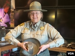 Lake Anna State Park Chief Ranger Lauri Schular holds a rock and a pan that are part of the Virginia park's exhibition on the area's gold mining history. (Steve Herman/VOA)