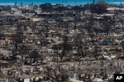 FILE - Charred remains of homes are visible following a wildfire in Lahaina, Hawaii, Aug. 22, 2023.