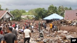 Rescuers and villagers search for missing people following a flash flood that killed a number of people in Rua, Ternate Island, Indonesia, Aug. 25, 2024. 