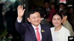 Thailand's former Prime Minister Thaksin Shinawatra, left, with his daughter Paetongtarn Shinawatra arrives at Don Muang airport in Bangkok, Thailand, Aug. 22, 2023. 