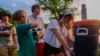 Pemandu kemping Izzy Kellar dari Dayton, Ohio, mengisi botol air peserta kemping, Kamis, 20 Juni 2024, di YMCA Camp Kern di Oregonia, Ohio. (Foto: AP/Joshua A. Bickel)
