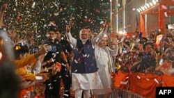 印度总理纳伦德拉·莫迪在新德里抵达印度人民党(BJP)总部庆祝该党在议会大选中获胜时打起胜利的手势。（2024年6月4日）