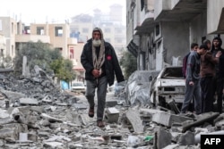 On March 13, 2024, in Deir el-Balah, central Gaza Strip, the home of Palestinian al-Atrash was destroyed in an Israeli attack. A man found his way through the rubble.