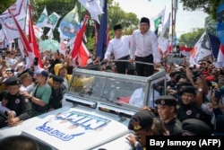 Calon presiden dan wakil presiden Indonesia Anies Baswedan (tengah kiri) dan Muhaimin Iskandar (tengah kanan) menyapa pendukung yang berkumpul di depan KPU di Jakarta pada 19 Oktober 2023. (Foto: AFP)