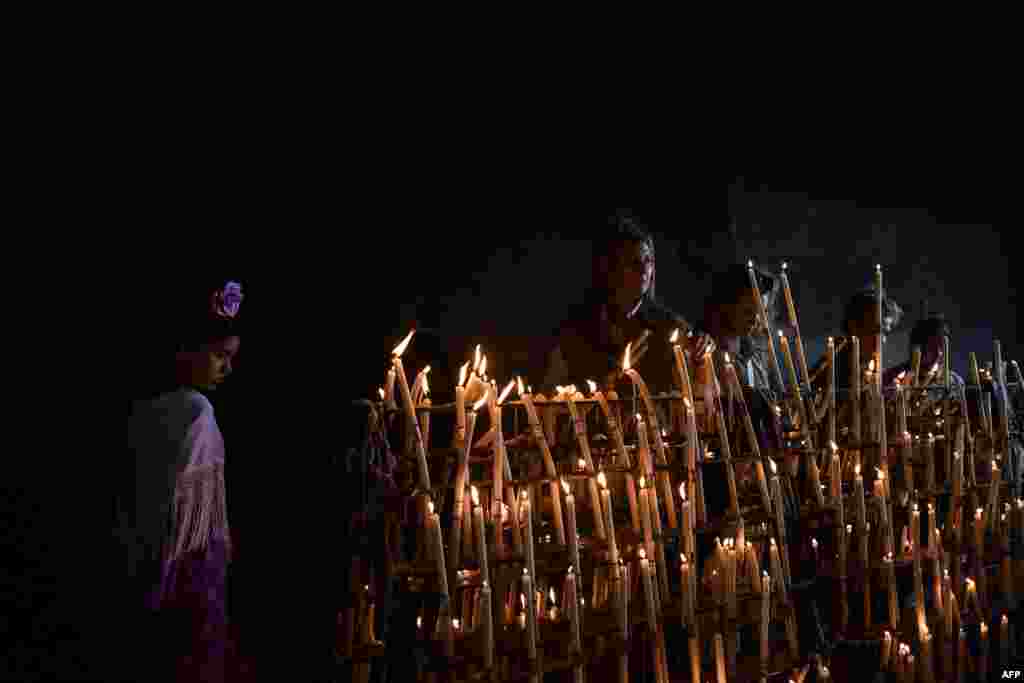 Pilgrims light candles at the Rocio church during the annual pilgrimage in El Rocio village, Spain.