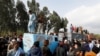 Supporters of former Pakistani Prime Minister Imran Khan climb on shipping containers, placed to block the road, during a clash outside the federal judicial complex in Islamabad, March 18, 2023.