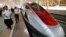 FILE - People walk near a high-speed train during its testing phase at Halim station in Jakarta, Indonesia, Sept. 18, 2023.