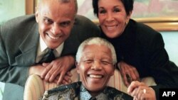 FILE - American actor and singer Harry Belafonte (L) and his wife Julie pose with South African president Nelson Mandela (C) in Pretoria 15 June 1999. 