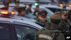 Oficiales de policía chilenos parados junto a sus patrullas durante una ceremonia para iniciar el programa "Calles sin violencia" patrocinado por el gobierno, en Santiago, Chile, el lunes 24 de abril de 2023.
