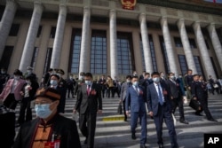 全国人大代表在周五会议结束后走出北京人大会堂。（2023年3月10日）
