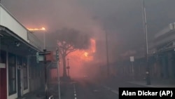 Smoke and flames from wildfires fill the air on Front Street in downtown Lahaina, on the island of Maui in the state of Hawaii, Aug. 8, 2023. Maui officials say the fire has destroyed dozens of homes and businesses in the historic town of Lahaina. (Alan Dickar via AP)