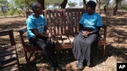 Siridzayi Dzukwa, a grandmother, right, talks to a colleague while seated at a bench in Hatfcliffe on the outskirts of the capital Harare, Zimbabwe, May 11, 2024.