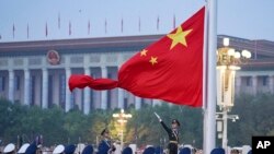 FILE - In this photo released by Xinhua News Agency, a Chinese honor guard unfurls the Chinese national flag during a flag-raising ceremony to mark the 73rd anniversary of the founding of the People's Republic of China held at Tiananmen Square in Beijing, Oct. 1, 2022.