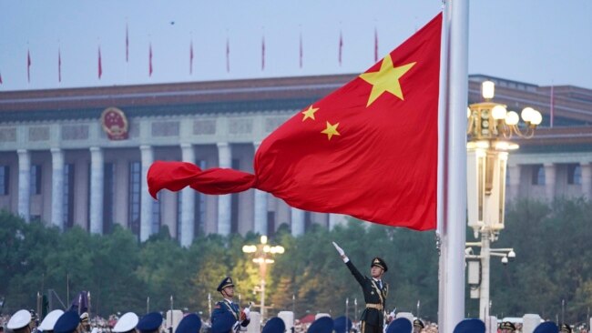 FILE - In this photo released by Xinhua News Agency, a Chinese honor guard unfurls the Chinese national flag during a flag-raising ceremony to mark the 73rd anniversary of the founding of the People's Republic of China held at Tiananmen Square in Beijing, Oct. 1, 2022.