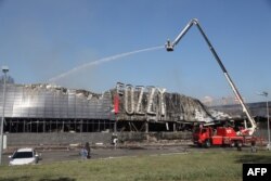 Rescatistas ucranianos rocían con agua un supermercado destruido como resultado de un ataque nocturno en Odesa, el 14 de agosto de 2023.