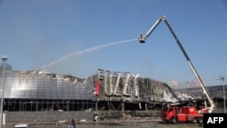 Ukrainian rescuers spray water on a supermarket destroyed as a result of night strike in Odesa, Aug. 14, 2023. Ukraine downed three waves of Russian missiles and drones targeting Odesa, its army said early Aug. 14, 2023.