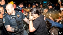 FILE - Officers of the Metropolitan Police Department pepper spray demonstrators at George Washington University in Washington, May 8, 2024. 