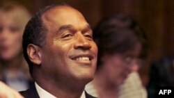 O.J. Simpson ajuste sa cravate avant son procès à la cour de circuit de Miami le 9 octobre 2001. Simpson est décédé à l'âge de 76 ans, a annoncé sa famille le 11 avril 2024. (Photo par AL DIAZ / POOL / AFP)