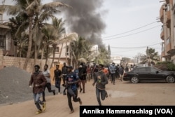 Protesters run from tear gas in Dakar, Senegal, March 16, 2023.
