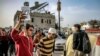 FILE - A man assists another to carry an intravenous solution bag for him as they walk outside the Ahli Arab hospital in Gaza City on March 27, 2024