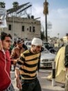 FILE - A man assists another to carry an intravenous solution bag for him as they walk outside the Ahli Arab hospital in Gaza City on March 27, 2024