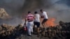 FILE - Local residents try to extinguish a fire, near the seaside resort of Lindos, on the Aegean Sea island of Rhodes, southeastern Greece, on July 24, 2023.