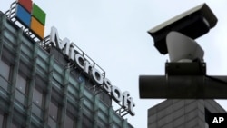 FILE - A security surveillance camera is seen near the Microsoft office building in Beijing, July 20, 2021. 