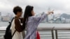 两名中国年轻人五一节前到香港游玩时在小红书上寻找旅游攻略。（2024年4月30日）