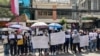 FILE - Supporters of online media outlet Voice of Democracy (VOD) hold placards in front of VOD office in Phnom Penh, Feb. 13, 2023.