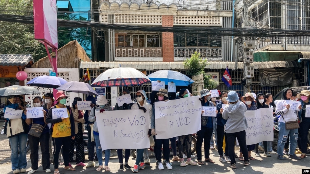 FILE - Supporters of online media outlet Voice of Democracy (VOD) hold placards in front of VOD office in Phnom Penh, Feb. 13, 2023.