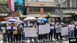 FILE - Supporters of online media outlet Voice of Democracy (VOD) hold placards in front of VOD office in Phnom Penh, Feb. 13, 2023.