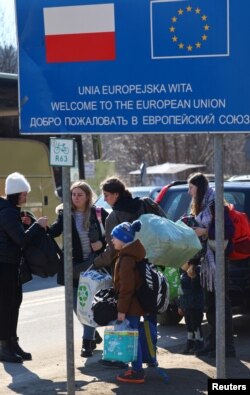 Sebuah keluarga dari Lviv, Ukraina, tiba di pos pemeriksaan perbatasan di Kroscienko, Polandia, melintasi perbatasan dari Polandia ke Ukraina, setelah mereka membuat keputusan untuk kembali ke negaranya karena tidak dapat menemukan tempat tinggal di Polandia, 17 Maret 2022. (REUTERS/Fabrizio Bensch)