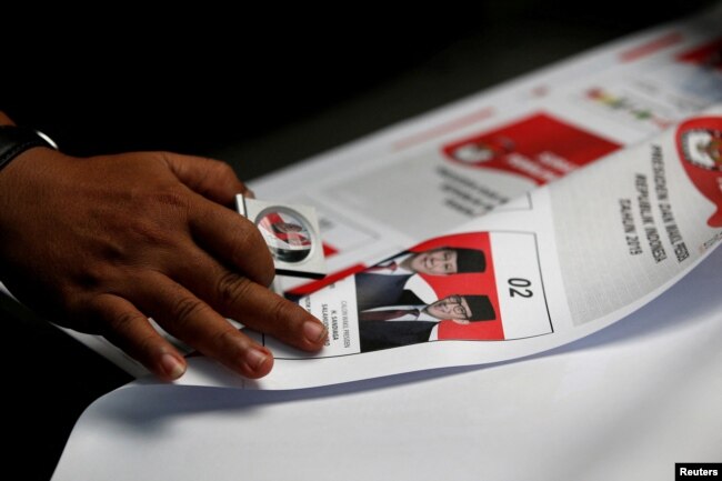 Seorang pekerja menggunakan kaca pembesar saat memeriksa surat suara yang dicetak untuk pemilihan presiden mendatang di sebuah pabrik di Jakarta, 20 Januari 2019. (Foto: REUTERS/Willy Kurniawan)