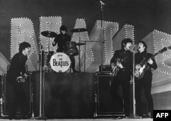 FILE - This photo taken on June 30, 1966 shows The Beatles, (L to R) Paul McCartney, Ringo Starr, George Harrison and John Lennon, performing during their concert at the Budokan in Tokyo. (Photo by JIJI PRESS / JIJI PRESS / AFP)