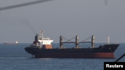 Palau-flagged bulk carrier Aroyat and general cargo vessel Resilient Africa, in background left, arrive at the port of Chornomorsk for loading with grain, near Odesa, Ukraine, Sept. 16, 2023. 