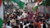 Rahul Gandhi, a senior leader of India's main opposition Congress Party, center, and his sister and party leader Priyanka Gandhi Vadra, center-right, are greeted as they drive through Mumbai, March 16, 2024, during their "Unite India Justice March."