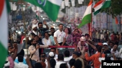 Rahul Gandhi, a senior leader of India's main opposition Congress Party, center, and his sister and party leader Priyanka Gandhi Vadra, center-right, are greeted as they drive through Mumbai, March 16, 2024, during their "Unite India Justice March."