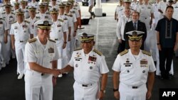 美国第七舰队司令卡尔·托马斯中将（左）和菲律宾海军 2023“萨玛萨玛”演习司令官托里比奥·阿达西中将（中）在美菲年度海军演习的开幕式上握手。（2023年10月2日）