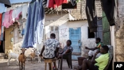 Salamba Ndiaye, center, a 28-year-old who tried to migrate to Europe twice, is photographed at her family house in Thiaroye-Sur-Mer, Senegal, Aug. 23, 2024.