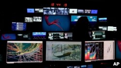 Shannon Hoy, an expedition coordinator, stands in front of control room screens inside the NOAA Okeanos Explorer, in Kodiak, Alaska, June 23, 2023.