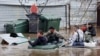Люди на надувных лодках во время наводнения в городе Оренбурге, Россия, 10 апреля 2024 года