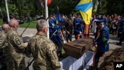 FILE - Soldiers lower the coffin of Andrii Konyaev during his funeral in Fastiv, Ukraine, on May 23, 2023. He and more than 50 Ukrainians died in the July 29, 2022, explosions at Olenivka, a Russia-controlled prison camp in eastern Ukraine.