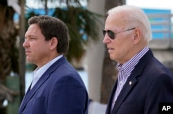 FILE - U.S. President Joe Biden and Florida Governor Ron DeSantis arrive to tour an area impacted by Hurricane Ian on Oct. 5, 2022, in Fort Myers Beach, Florida.