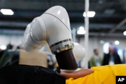 Seorang peserta menerima pijatan dari robot pijat berbantuan iYU AI, oleh Capsix Robotics pada pameran teknologi CES di Las Vegas, Rabu, 10 Januari 2024. (AP/Ryan Sun)