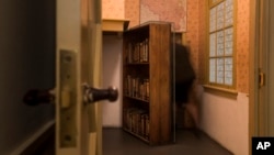FILE - A woman enters the secret annex at the renovated Anne Frank House Museum in Amsterdam, Netherlands, Nov. 21, 2018.