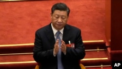 FILE - Chinese President Xi Jinping applauds during the opening session of the annual meeting of China's National People's Congress at the Great Hall of the People in Beijing, on March 5, 2022.