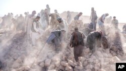 Afghan volunteers clean up rubble after an earthquake in Zenda Jan district in Herat province, western Afghanistan, Oct. 11, 2023.