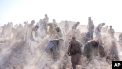 Sukarelawan Afghanistan membersihkan puing-puing setelah gempa bumi di distrik Zenda Jan di provinsi Herat, Afghanistan barat, Rabu, 11 Oktober 2023. (AP/Ebrahim Noroozi)