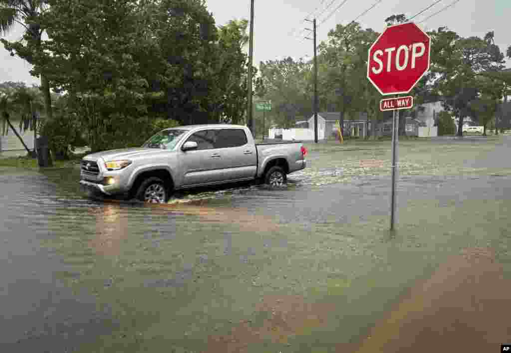 Un conductor navega por una calle inundada en el área de Shore Acres, en St. Petersburg, Florida.